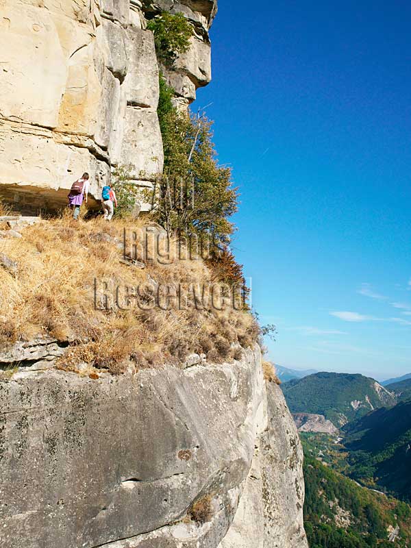 AERIAL VIEW photo of hiker hiking on a narrow ledge, cliff, rock face, Annot, French Alps, FRANCE. VUE AERIENNE randonnée dans les grés d'Annot, Alpes Françaises, Alpes-de-Haute-Provence.