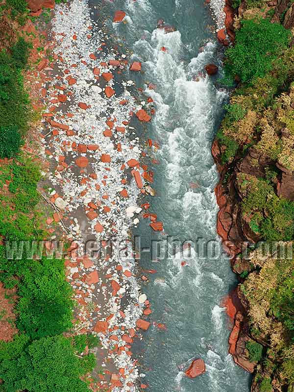 AERIAL VIEW photo of a riverbed with large red boulders, Var River, Gorges de Daluis, French Alps, France. VUE AERIENNE rocher rouge, fleuve le Var, Alpes-Maritimes.