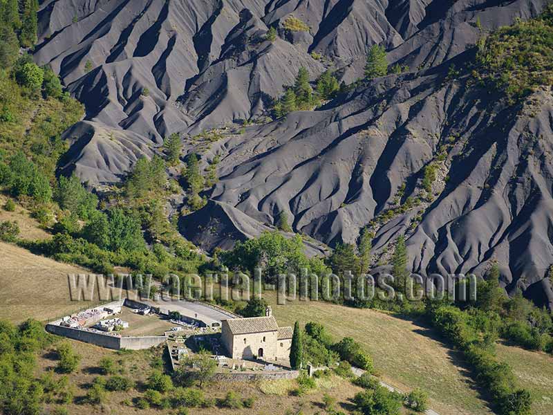 Aerial view of an remote chapel in a landscape of ravines in the Alps, France. Vue aérienne.