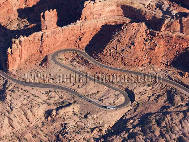 Aerial view of a winding road with red sandstone cliff, Arches National Park, Utah, USA.